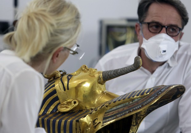  Cientistas Christian Eckman e Katja Broschat examinam máscara mortuária de Tutancâmon: barba foi colada com massa de epóxi depois que funcionário a derrubou sem querer  (Foto: AP Photo/Amr Nabil)