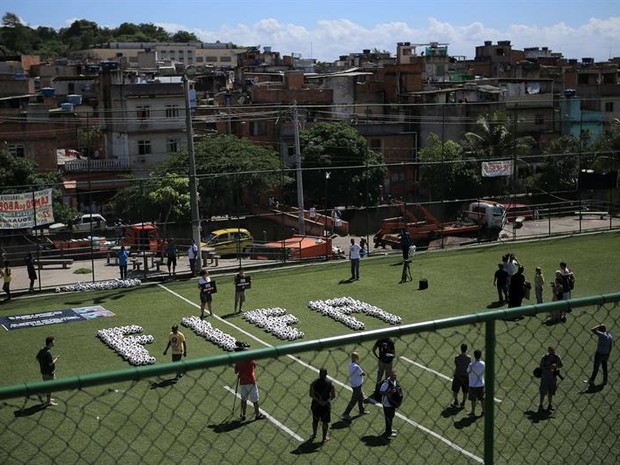 Crianças pintaram cruzes vermelhas em bolas de futebol (Foto: Agência EFE)