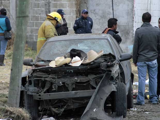 Chapéus de algumas vítimas são colocados no capô de um carro danificado pela explosão de um veículo carregado com fogos de aritifício. (Foto: J. Guadalupe Perez / AP Photo)