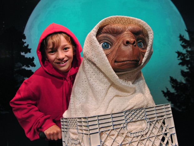 Ao lado da estátua de cera do personagem 'E.T', britânico Jacob Haughton, 12, imita o ator Henry Thomas em cena do longa 'E.T. - O extraterrestre' no museu Madame Tussauds em Londres, na Inglaterra (Foto: Carl Court/AFP)