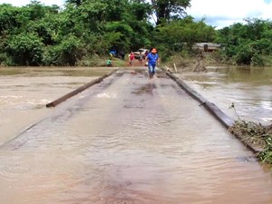 Ponte que dá acesso a cidade está quase submersa pelo rio (Foto: site Água Boa News)