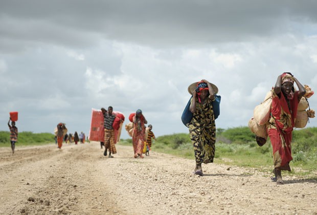 Moradores da Somália deixam campo desmontado devido a tempestade carregando todos os seus pertences nesta terça-feira (12) (Foto: AU-UN IST, Tobin Jones/AP)
