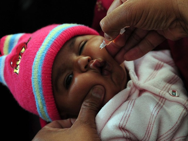 Bebê paquistanês recebe a gotinha da vacina contra poliomielite em um centro de saúde em Karachi. (Foto: Rizwan Tabassum/AFP)