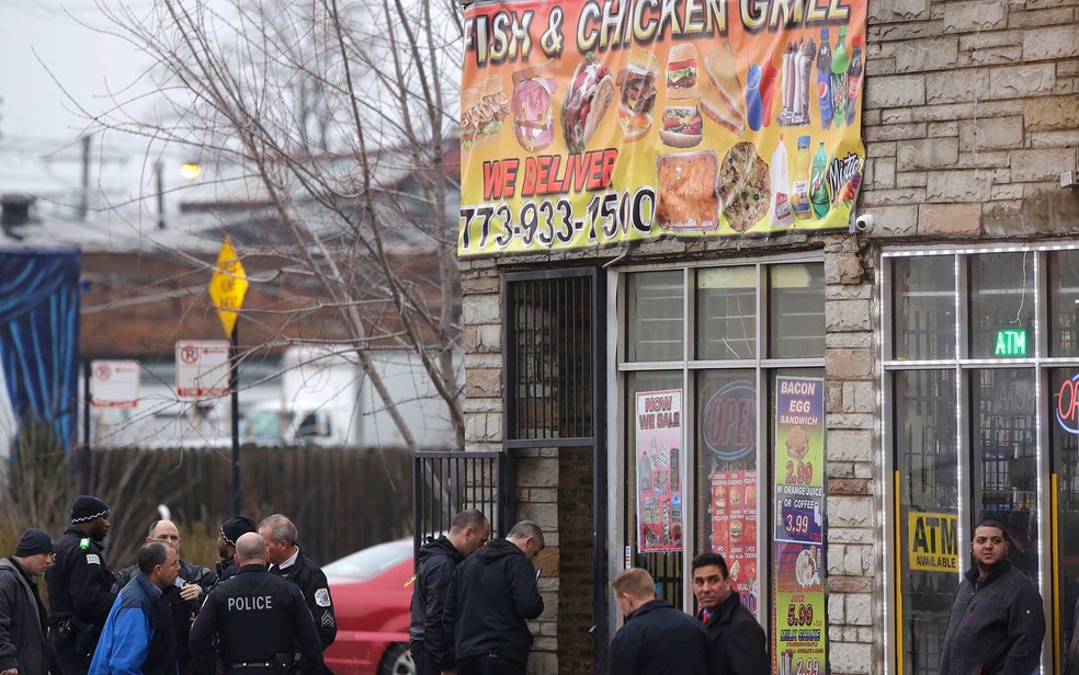 Oficiais de polícia de Chicago investigam cena onde quatro pessoas foram por um atirador em um restaurante (Foto: Joshua Lott / Getty Images / AFP Photo)