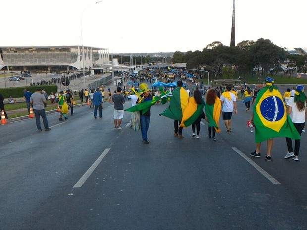 Manifestantes enrolados em bandeiras do Brasil seguem em direção ao Palácio do Planalto para participar de protesto contra o governo da presidente Dilma Rousseff (Foto: Alexandre Bastos/G1) Manifestantes enrolados em bandeiras do Brasil seguem em direção ao Palácio do Planalto para participar de protesto contra o governo da presidente Dilma Rousseff (Foto: Alexandre Bastos/G1)