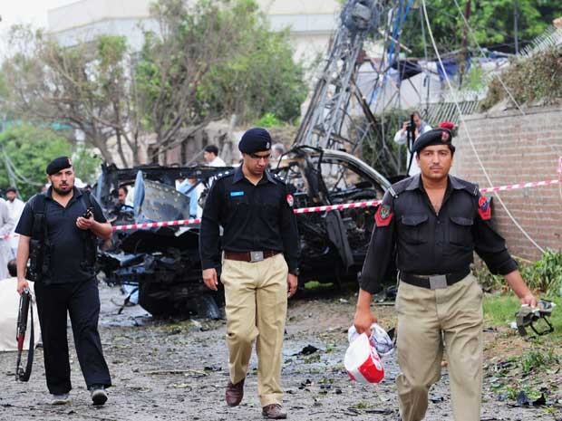 Policiais paquistaneses recolhem provas em local de explosão de carro. Ataque ocorreu perto do consulado dos EUA no país. (Foto: A Majeed / AFP Photo)