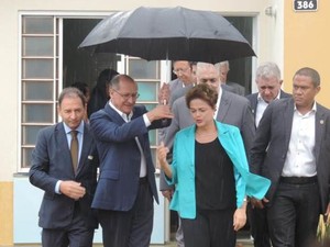 Geraldo Alckmin segura guarda-chuva para presidente Dilma (Foto: Marcos Lavezo/G1)