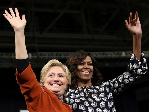 Hillary Clinton e Michelle Obama acenam ao público em comício nesta quinta-feira (27) na Carolina do Norte (Foto: REUTERS/Carlos Barria)