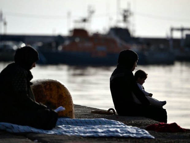 Mulher sentada no porto da ilha grega de Chios, onde estão acampados nesta terça-feira (5) os refugiados que deixaram centro de refugiados há alguns dias (Foto: Louisa Gouliamaki / AFP)