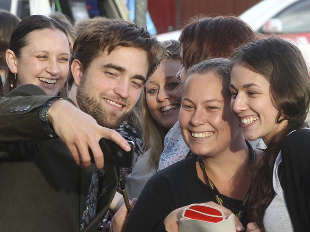 Robert Pattinson posa com fãs durante lançamento de 'A saga Crepúsculo: Amanhecer - parte 2' em Sydney, na Austrália, nesta segunda-feira (22) (Foto: AP/Rob Griffith)