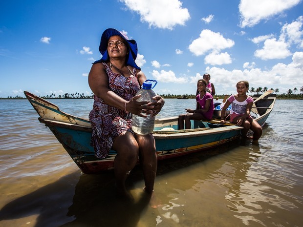 Famílias inteiras navegam rio acima para conseguir água doce (Foto: Jonathan Lins/G1)