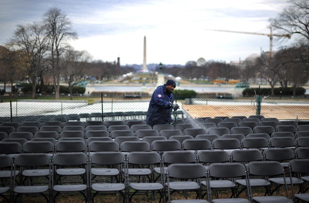 Homem limpa as cadeiras dos convidados (Foto: Jewel Samad/AFP)