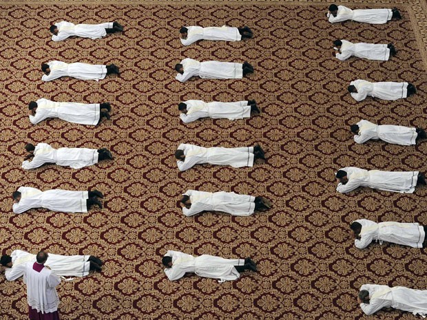 Sacerdotes deitaram no chão da Basílica de São Pedro durante a cerimônia (Foto: Giorgio Onorati/Reuters)