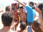 Cercada por homens, Nicole Bahls vai a praia de Ipanema, no Rio