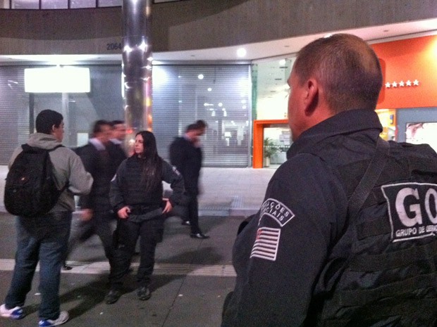 Policial do Grupo de Operações Especiais (GOE) da Polícia Civil acompanha a saída dos frequentadores e funcionários do shopping Center 3 (Foto: Glauco Araújo/G1)
