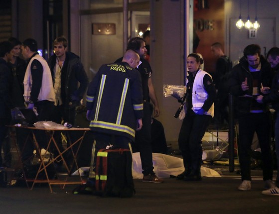 Equipes de resgate chegam ao local onde aconteceu o tiroteio, no centro de Paris (Foto: AP Photo/Thibault Camus)