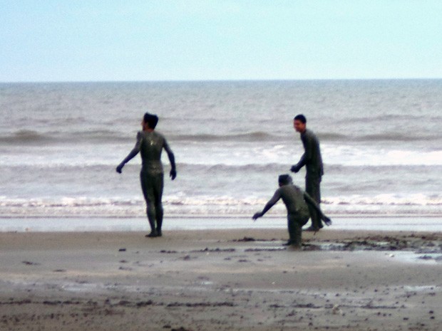 Jovens se divertem com areia contaminada na Praia do Cassino (Foto: Ana Stela Goldbeck/Arquivo pessoal)