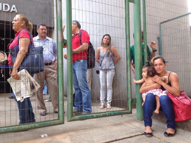 Usuários sentam em frente a sede da Receita Federal em Rio Branco (Foto: Caio Fulgêncio/ G1)