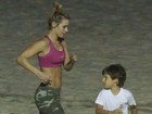 Com o filho caçula, Carolina Dieckmann malha em praia do Rio