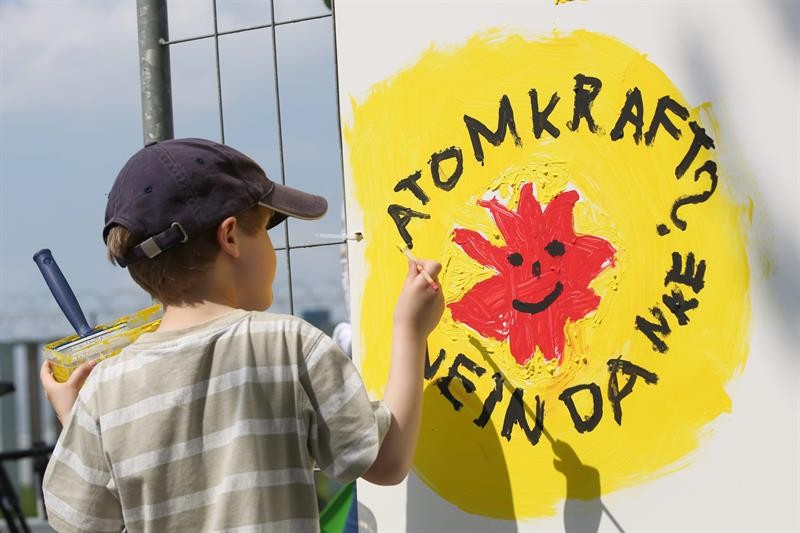 Menino de 6 anos pinta a frase de ordem do protesto - “Energia nuclear? Não, obrigado” – na parede da usina de Brokdorf, na Alemanha