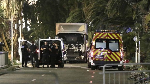 Policiais permanecem junto ao caminhão usado contra a multidão que acompanhava os fogos de artifício da festa da Bastilha, em Nice (Foto: Franck Fernandes/EFE)