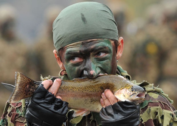 Soldado come peixe vivo em exercício militar. (Foto: Karen Minasyan/AFP)