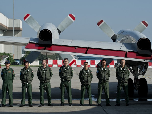 Integrantes da Força Aérea japonesa posam antes de decolar para se juntar às buscas por avião desaparecido. (Foto: Mohd Rasfan/AFP)