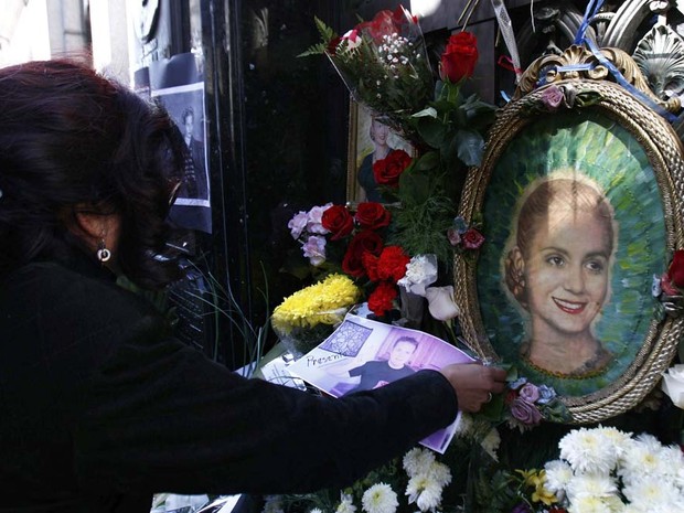 Uma mulher coloca uma foto de um parente desaparecido no túmulo do ex-primeira-dama Eva Perón, para comemorar o 60 º aniversário de sua morte no cemitério da Recoleta, em Buenos Aires. (Foto: Marcos Brindicci/Reuters)