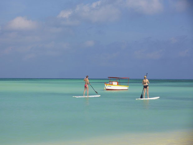 Turistas praticam stand up paddle (espécie de surfe com remo) em uma praia de Aruba (Foto: Divulgação/Aruba Tourism Authority)