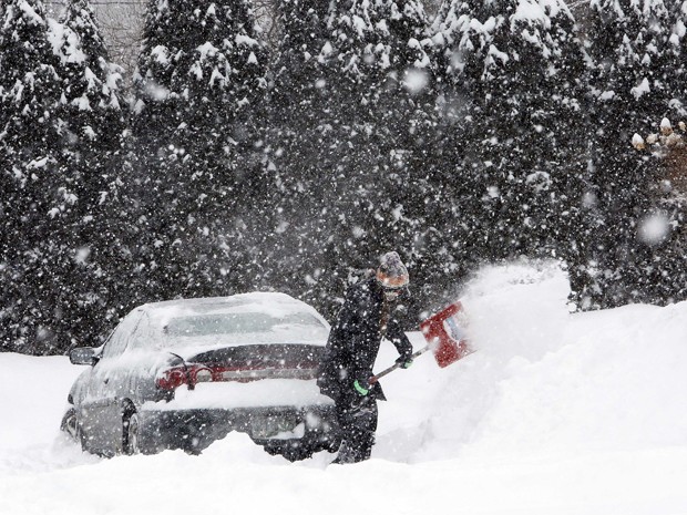 Krystal Koban retira neve que cobriu seu carro durante nevasca na segunda-feira (2), em Henniker, New Hampshire  (Foto: AP Photo/Jim Cole)