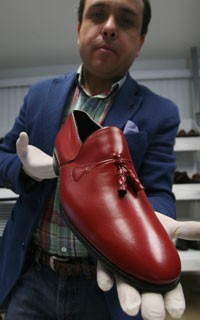 O sapateiro mexico Armando Martín segura os calçados vermelhos feitos para o Papa Bento XVI (Foto: Alfredo Valadez / France Presse)