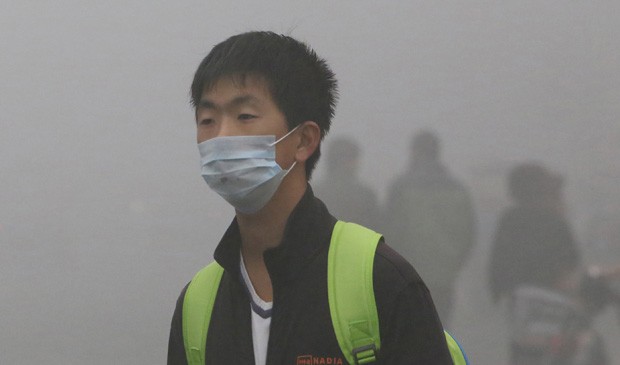 Jovem usa máscara para evitar riscos à saúde provocados pela poluição na China. (Foto: China Out/AFP)