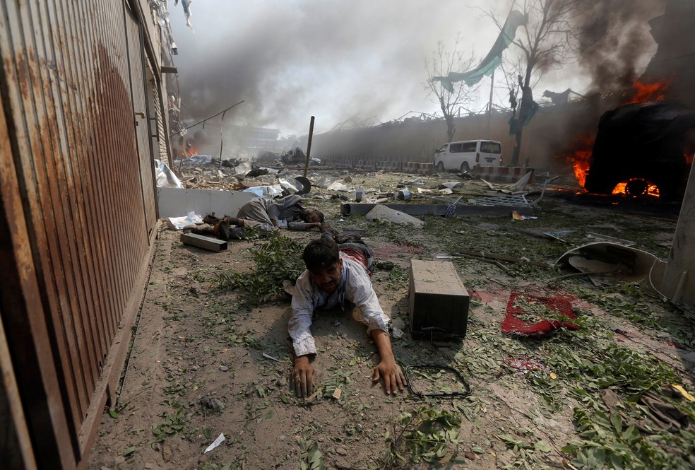 Homem ferido se arrasta após explosão no bairro das embaixadas em Cabul, no Afeganistão, nesta quarta-feira (31)  (Foto: Omar Sobhani/ Reuters)