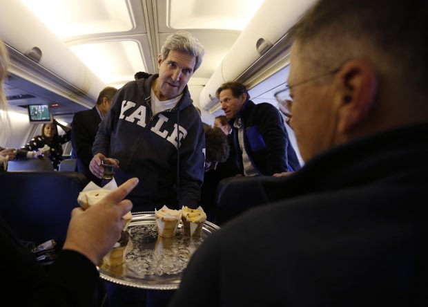 O secretário de Estado dos EUA, John Kerry, oferece cupcakes a jornalistas neste domingo (3) no avião antes da chegada ao Cairo (Foto: AFP)