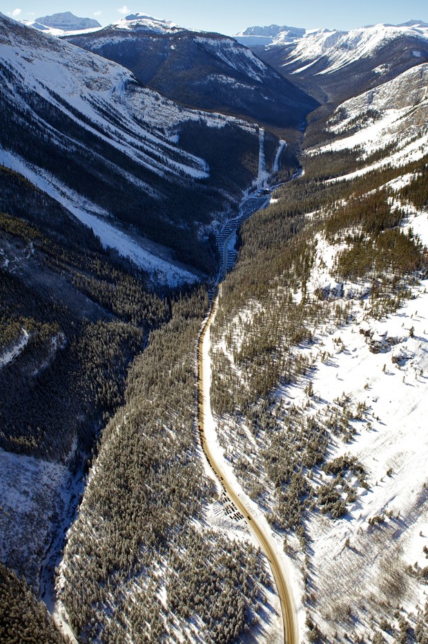 Helicopter aerial view of Access Road, Parking, Base Lodge, Healy Creek and Ski Out at Sunshine Village Ski Resort with blue sky and full snow coverage on Rocky Mountains across the continental divide. (Foto: Getty Images/iStockphoto)