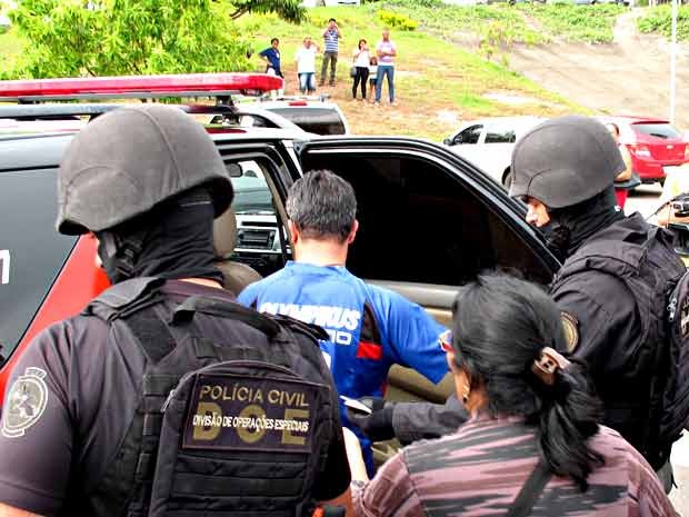 Homem que foi feito refém (de azul) deixa hospital do Paranoá em carro da Polícia Civil (Foto: Lucas Nanini/G1)