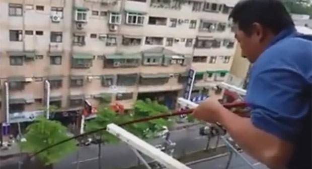 Homem fisgou peixe da sacada de prédio em Taiwan (Foto: Reprodução/YouTube/Vitaly Petrukhin)