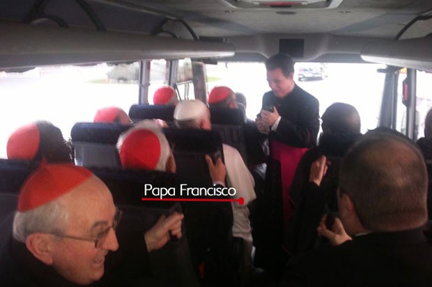 Imagem mostra o Papa Francisco sentado no ônibus conversando com um religioso. Sentado ao seu lado esquerdo está o cardeal brasileiro Dom Raymundo Damasceno (Foto: Frederico Henrique de Oliveira/Canção Nova)