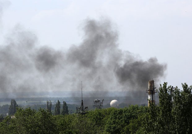 Fumaça é vista sobre área do aeroporto de Donetsk nesta segunda-feira (26). Local é palco de combates entre separatistas e forças ucranianas (Foto: Yannis Behrakis/Reuters)
