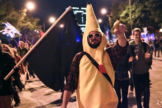 'Homem-banana' aponta uma banana de verdade contra policiais durante o protesto (Foto: Francis Vachon/AFP)