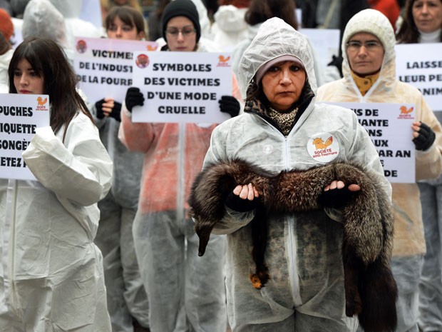 Atividade com pele de raposa em manifestação em Paris neste sábado (8) (Foto: Pierre Andrieu/ AFP)