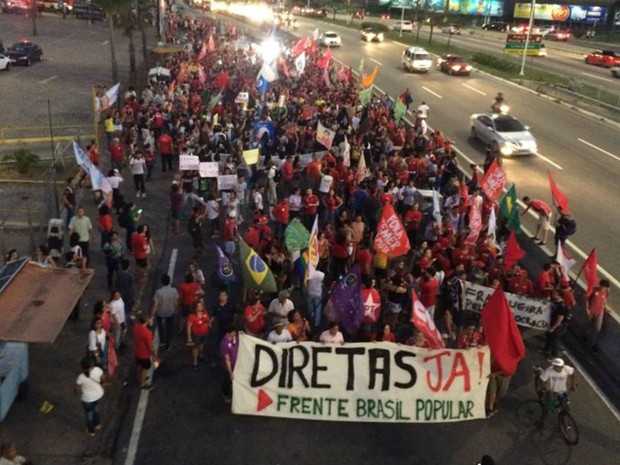 Com cartazes, faixas e bandeiras, os manifestantes ocupam faica da BR-101 (Foto: Renato Vasconcelos/ G1)
