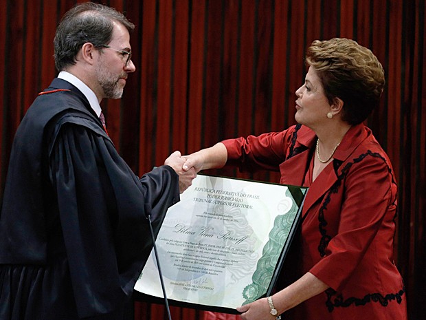 Presidente do TSE, ministro Dias Toffoli, cumprimenta a presidente Dilma Rousseff ao entregar o diploma que a autoriza a tomar posse em seu 2º mandato (Foto: Eraldo Peres/AP Photo)