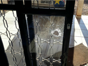 Marca da bala na porta de vidro do prédio da PM (Foto: Polícia Militar-MT)