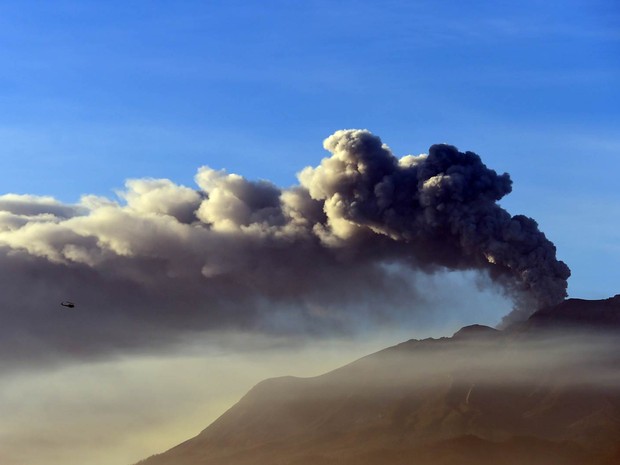 Helicóptero sobrevoa o vulcão Calbuco em erupão, visto de Puerto Varas, no Chile (Foto: Martin Bernetti/AFP)