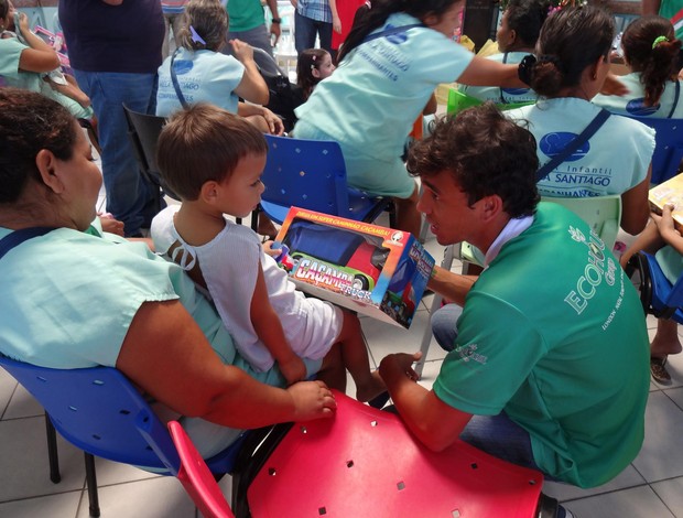 Felipe Moreira, do Alecrim, entrega presente à criança do Hospital Varela Santiago, em Natal (Foto: Gabriel Peres/Divulgação)