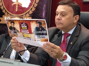 Procurador geral Héverton Aguiar lê folder de divulgação da Expo Show Rodeio (Foto: Gaia Quiquiô/G1)