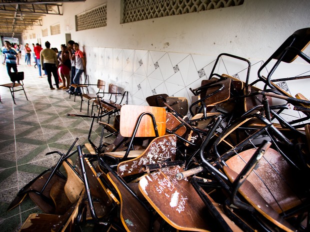 Cadeiras quebradas ficam amontoadas no corredor da Escola Municipal Mário Gomes  (Foto: Jonathan Lins/G1)