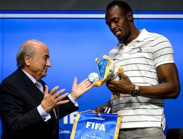 Usain Bolt ao lado do presidente da FIFA Joseph Blatter (Foto: Agência AFP)