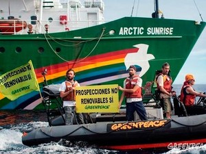 Ana Paula, à direita, pilota lancha durante ação na Espanha. Ao fundo, o Arctic Sunrise (Foto: Arturo Rodriguez/Greenpeace)